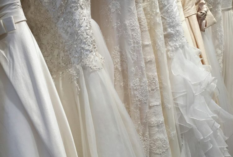 A row of beautiful lacy embellished bridal gowns in detailed exquisite fabrics